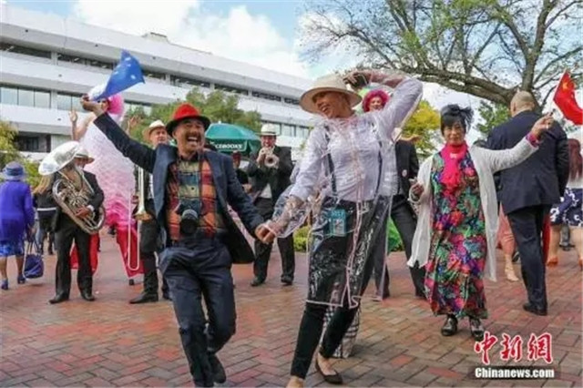 资料图片：中国游客参加“墨尔本赛马节”。图为一对来自中国的夫妇伴着乐队的音乐和歌声，与一位澳大利亚工作人员共舞。记者 陶社兰 摄