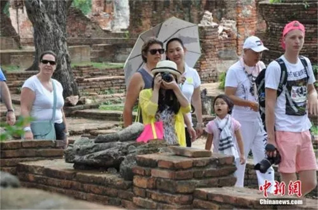 泰国大城府玛哈泰寺遗址里参观的各国游人。 中新社发 王雪 摄