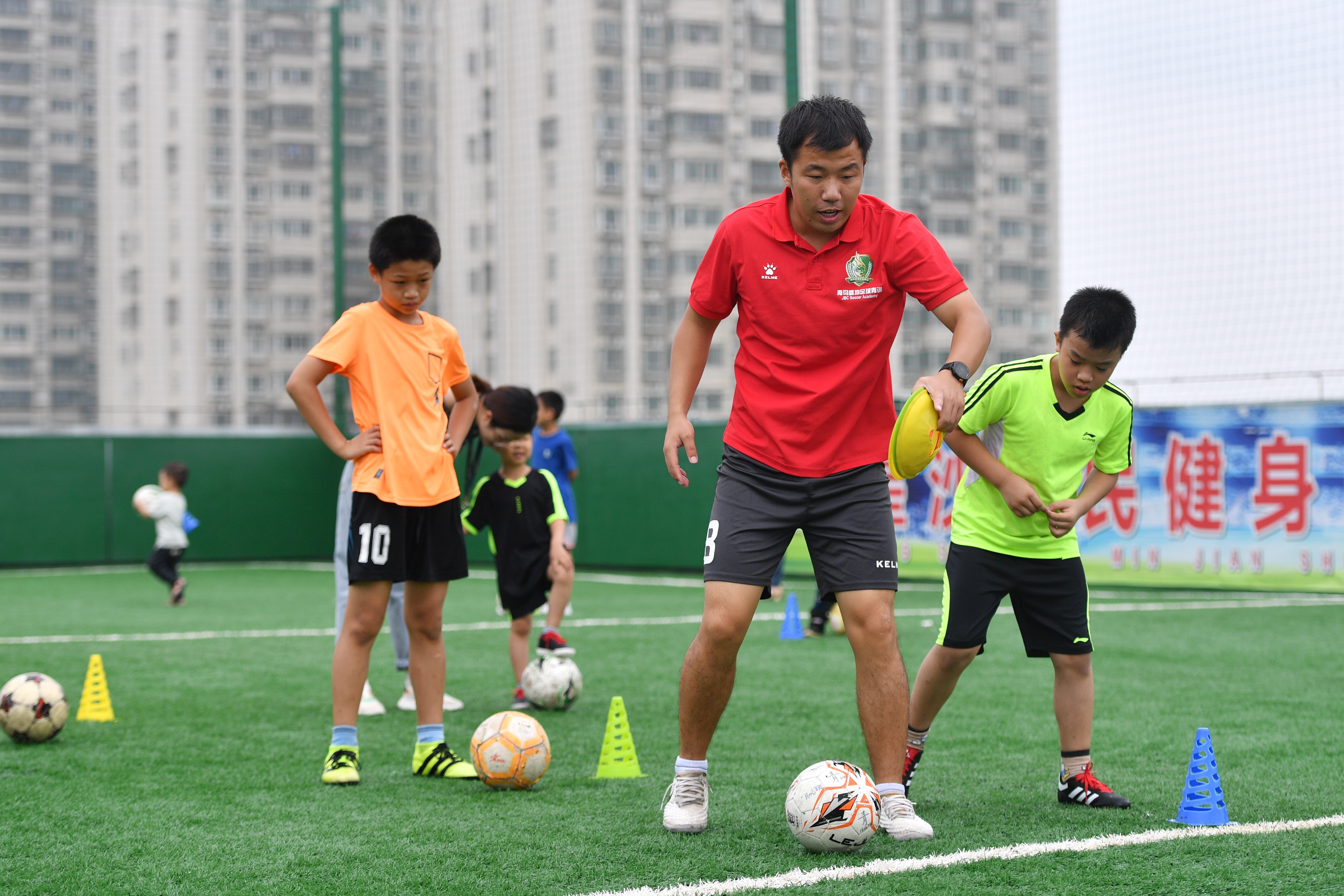7月20日，星沙全民健身中心内，孩子们在教练的指导下进行足球练习。