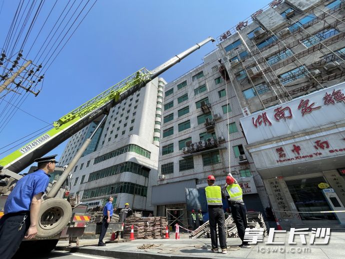14日上午，湘雅路上，开福区城管执法人员组织专业施工队伍对沿线违规招牌进行拆除。