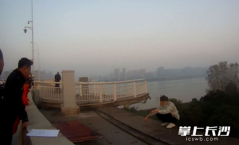 男子蹲在湘府路大桥桥边想要轻生。 均为执法记录仪截图