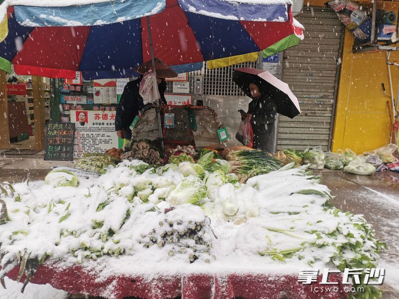火炬路附近的农贸市场，市民冒雪前来买菜。