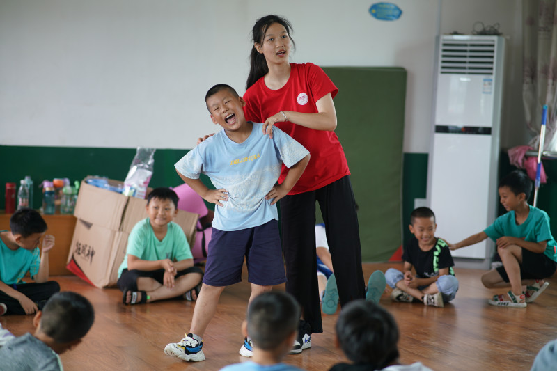 志愿者教孩们舞蹈基本动作。