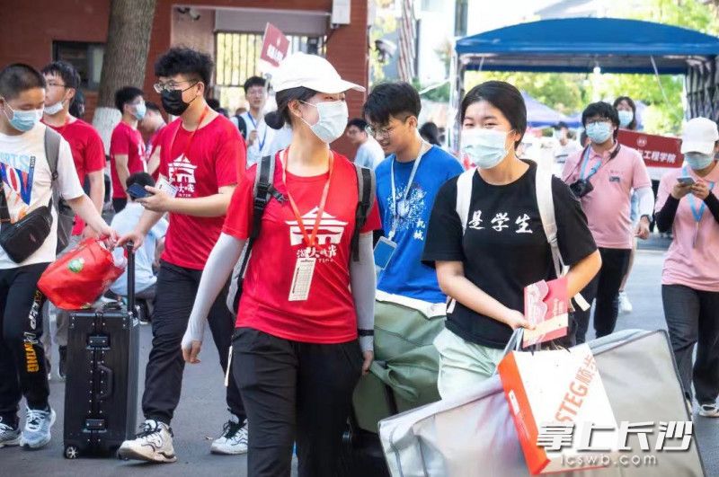 身穿红色衣服的“迎新志愿者”协助新生入校报到。湖南大学供图