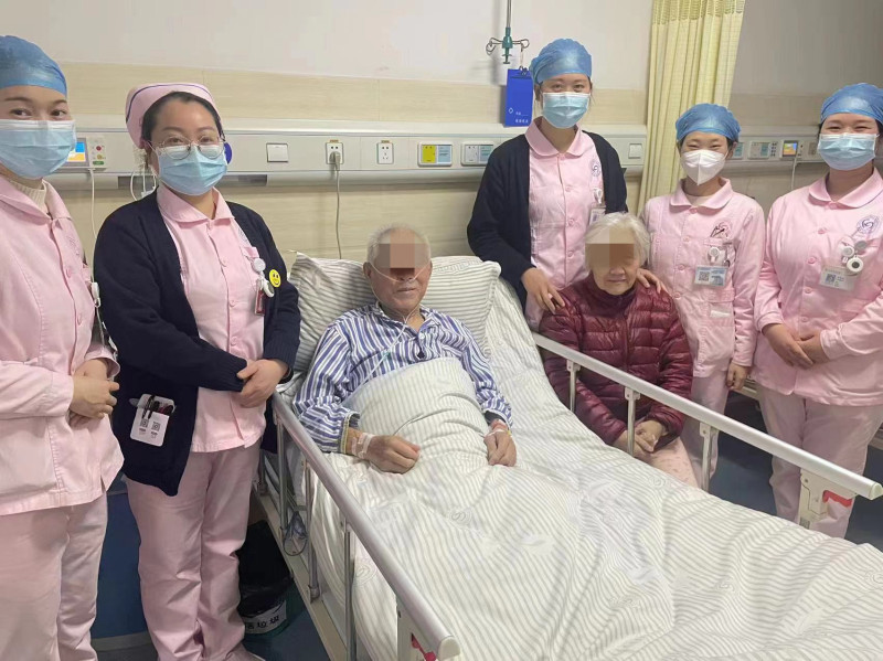 做完心脏支架手术后、病情稳定的的爹爹坐起来与医护人员留影。医院供图