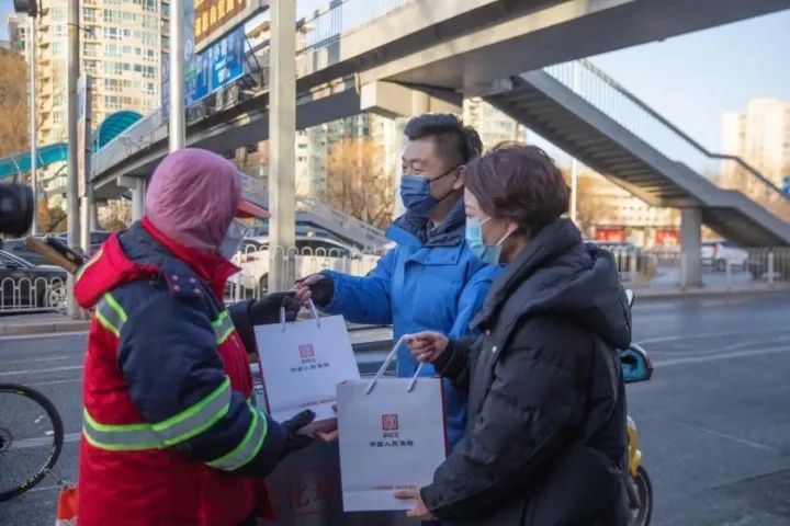 人保寿险的工作人员向北京市东城区一线环卫工人李秀华（左一）表示慰问。