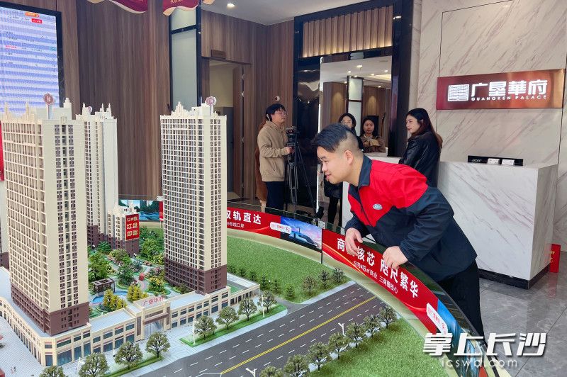 来自蓝思科技的青年工人刘自立在营销中心沙盘查看保租房项目所在的楼栋。