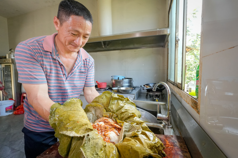 在宁乡资福红旗村的荷叶烧鸡老店，袁定明是第四代美食传承人，他用五层清香四溢的荷叶包裹腌制好的土鸡。