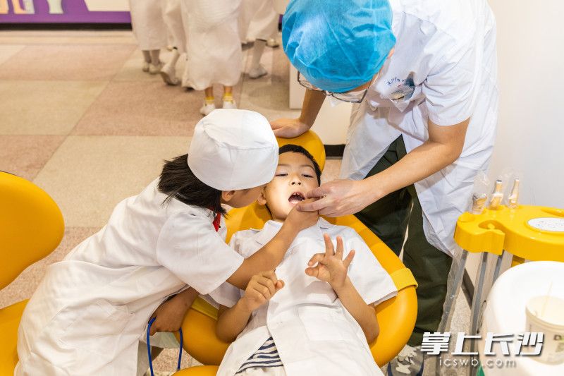 长沙市楚怡学校二年级甲班的孩子们在口腔健康科普馆沉浸式体验当“小牙医”。