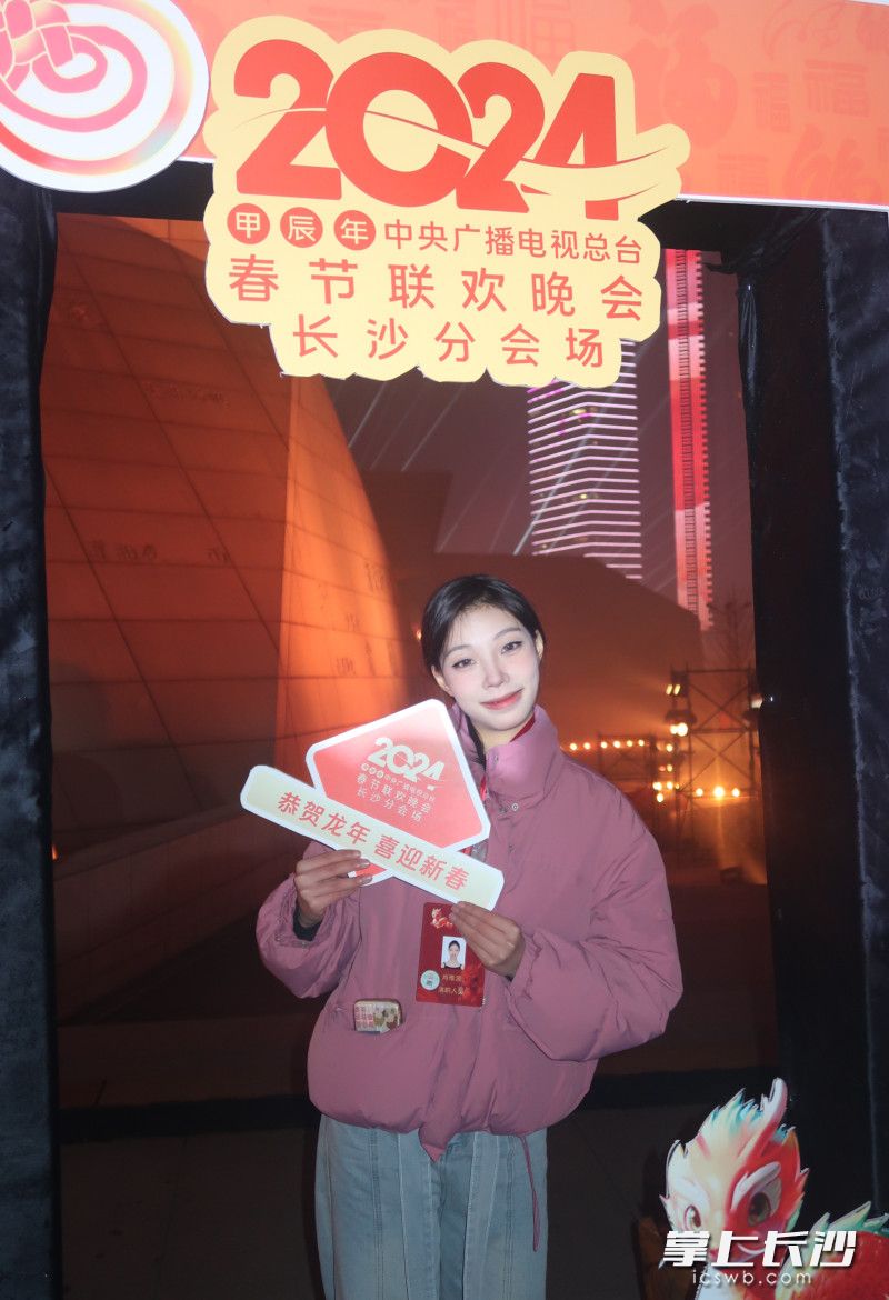 长沙学院学生肖雅源参与春晚演出，在背景板前打卡。