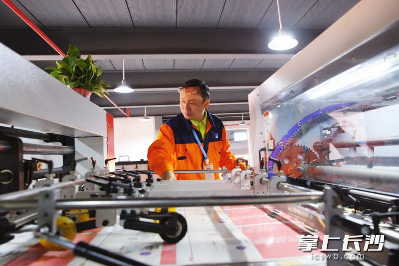 3月24日，华诚包装生产车间，工人正在查看全自动流水线生产情况。