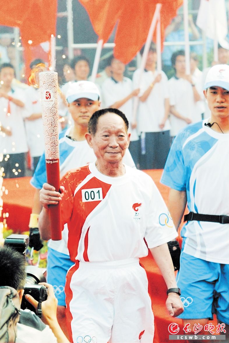 2008年6月 　　奥运火炬手袁隆平手持火炬传递圣火。