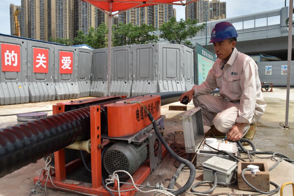 电力工人在操作电缆输送机。新华社记者白田田 摄
