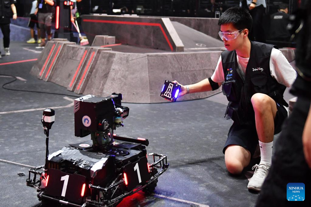 A contestant of team TOE from Dalian Jiaotong University tests a robot during the RoboMaster 2023 University Championship Regional Competition (South China) in Changsha, central China's Hunan Province, May 28, 2023. The four-day regional competition concluded in Changsha on Sunday, with team RobotPilots from Shenzhen University winning the first place and team TOE from Dalian Jiaotong University being the second. (Xinhua/Chen Zhenhai)